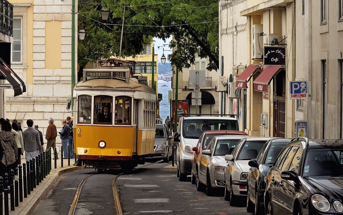 Yellow Tram 28 travelling through a street in central Lisbon