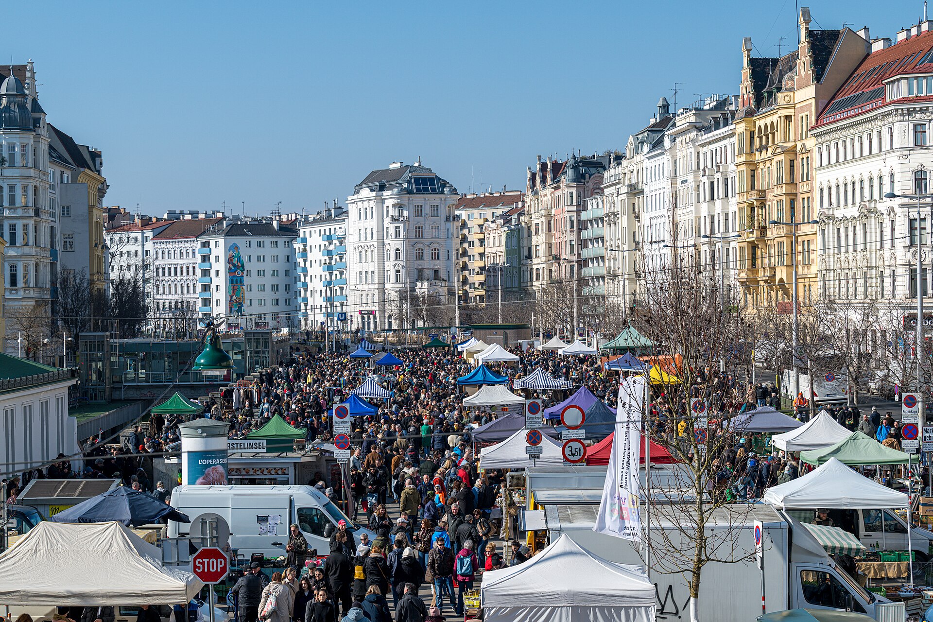 Shoppers browsing outdoor stalls at the Naschmarkt flea market in Vienna